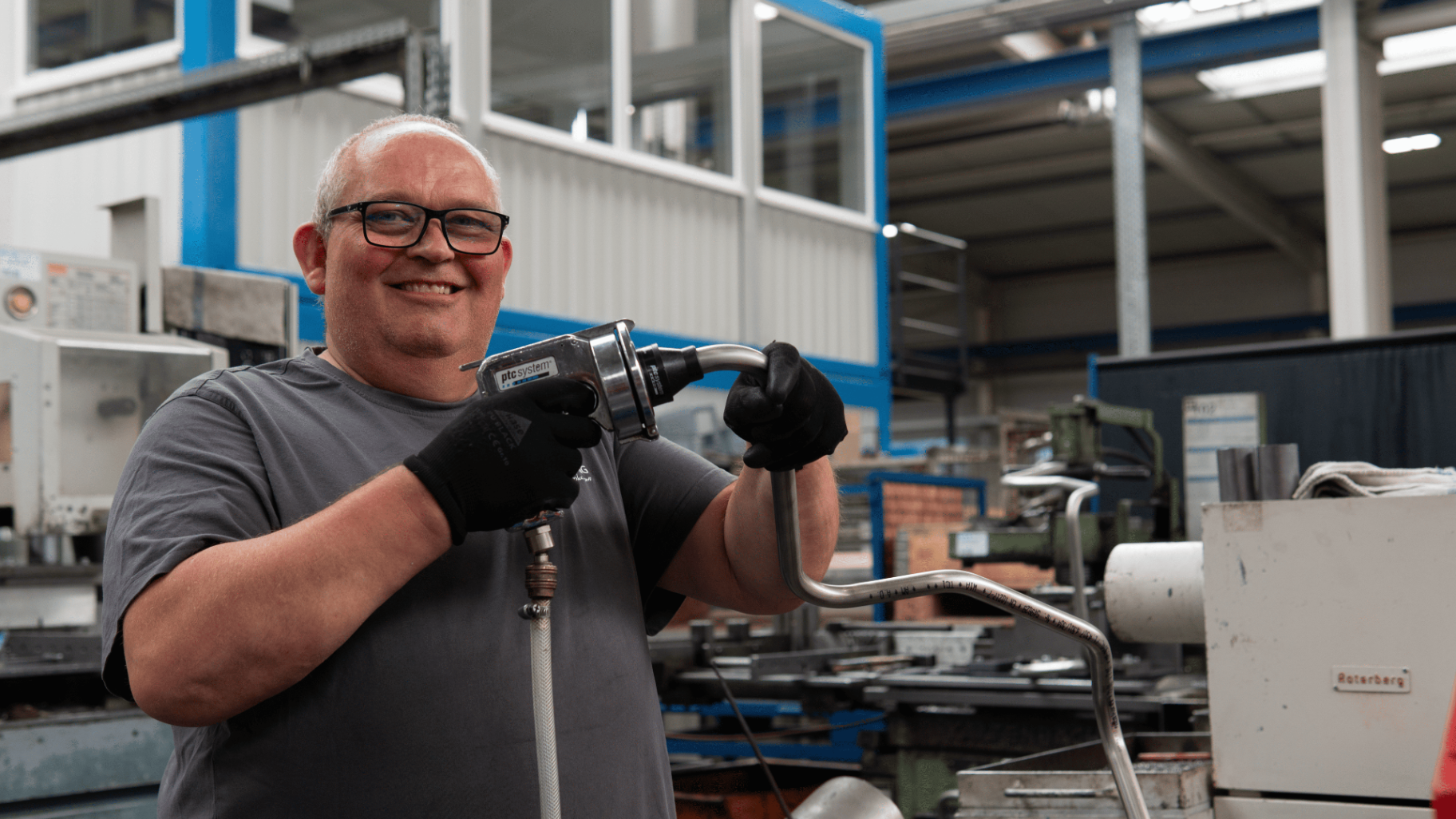 Mitarbeiter bei Tekton mit einem gebogenen Rohr am Arbeitsplatz